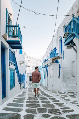 Yunan adası Mykonos 'ta tatilde olan genç adam, Mykonos Adası' ndaki küçük Venedik köyünde dinlenen adamlar.