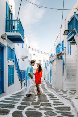 Mykonos Yunanistan, Yunan Adası Mykonos 'ta tatil yapan çift, küçük Venedik Mykonos' un beyaz caddelerinde giyinmiş kız ve erkek.