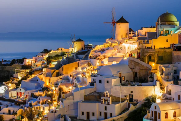 Σαντορίνη Οία Ελλάδα Ευρώπη, ηλιοβασίλεμα στο λευκό χωριό της Οίας Σαντορίνη με παλιές γαλάζιες και λευκές ελληνικές εκκλησίες το σούρουπο — Φωτογραφία Αρχείου