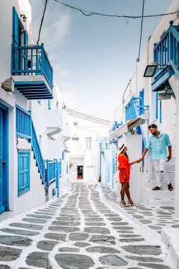 Mykonos Yunanistan, Yunan Adası Mykonos 'ta tatil yapan çift, küçük Venedik Mykonos' un beyaz caddelerinde giyinmiş kız ve erkek.