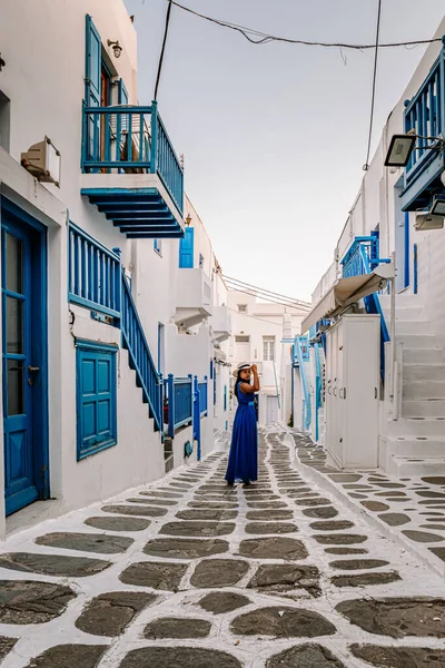 Mykonos Greece, woman on vacation at the Greek Island Mykonos, girl in dress at the white streets of little venice Mykonos