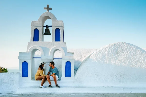 Couple on a luxury vacation in Greece, Oia Santorini men and woman at caldera infinity pool looking out over the ocean of Santorini Island — Stock Photo, Image