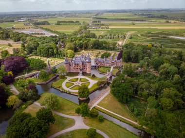 Hollanda Kalesi 'ndeki eski tarihi bahçe. Parlak bir yaz gününde genç bir çift ve erkek kale bahçesinde yürüyorlar.