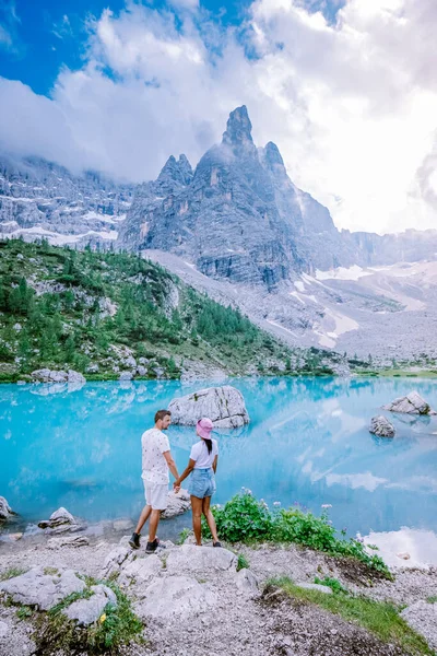 Couple visiter le lac bleu vert dans les Dolomites italiennes, beau lac Sorapis Lago di Sorapis dans les Dolomites, destination de voyage populaire en Italie — Photo