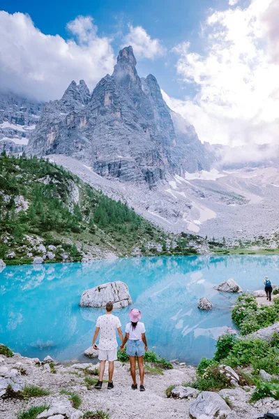 Couple visiter le lac bleu vert dans les Dolomites italiennes, beau lac Sorapis Lago di Sorapis dans les Dolomites, destination de voyage populaire en Italie — Photo