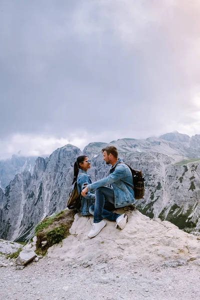 Pareja de senderismo en las dolomitas italianas durante el tiempo brumoso con nubes, Impresionante vista a los picos de Tre Cime en Dolomitas, Italia — Foto de Stock
