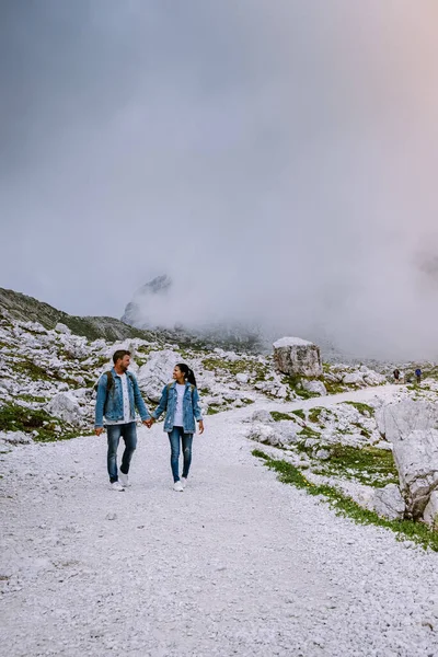 雲と霧の天気の間にイタリアのドロマイトでカップルハイキング,ドロミテ島のトレメ峰への見事な景色,イタリア — ストック写真