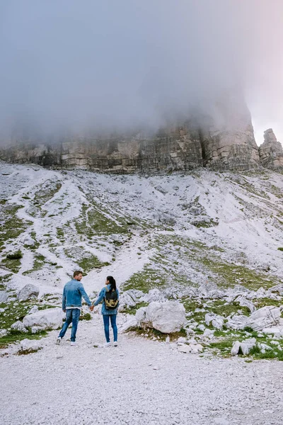 Koppel wandelen in de Italiaanse dolomieten tijdens mistig weer met wolken, Prachtig uitzicht op de toppen van de Tre Cime in Dolomieten, Italië — Stockfoto