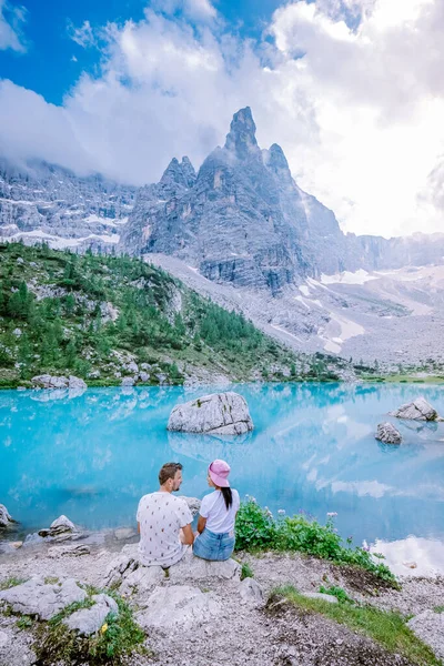 Couple visiter le lac bleu vert dans les Dolomites italiennes, beau lac Sorapis Lago di Sorapis dans les Dolomites, destination de voyage populaire en Italie — Photo