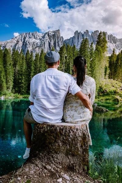 Couple visit hte bleu lake in the dolomites Italy, Carezza lake Lago di Carezza, Karersee with Mount Latemar, Bolzano province, South tyrol, Italy. Landscape of Lake Carezza or Karersee and Dolomites — Stock Photo, Image