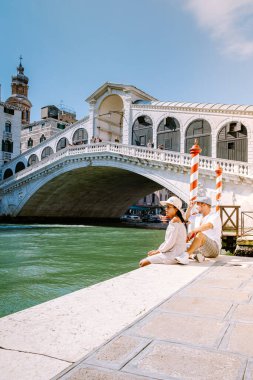 Venedik İtalya 'da Venedik' e şehir gezisine çıkan erkek ve kadın çifti Venedik 'teki ünlü Rialto köprüsüne bakıyor.