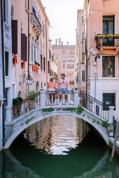 Casal homens e mulheres em uma viagem de cidade a Veneza Itália, ruas coloridas com canais Veneza — Fotografia de Stock