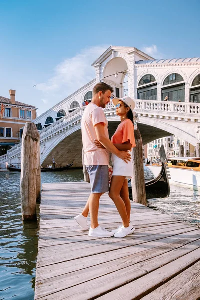 Pareja de hombres y mujeres en un viaje a Venecia Italia, calles coloridas con canales Venecia — Foto de Stock