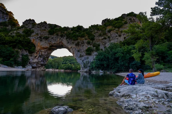 Paar aan het strand bij de rivier in de Ardeche France Pont d Arc, Ardeche Frankrijk, uitzicht op Narural arch in Vallon Pont Darc in Ardeche canyon in Frankrijk — Stockfoto