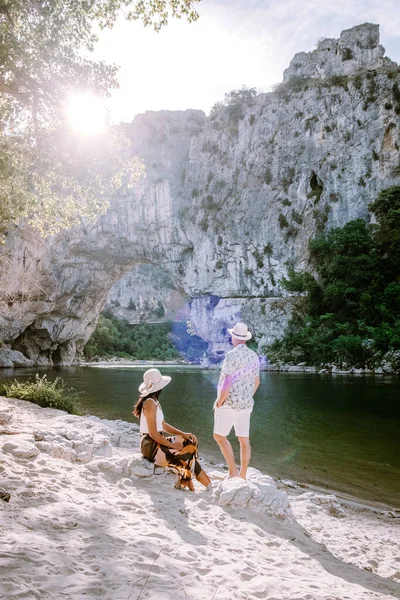 Пара на пляже у реки в Ardeche France Pont d Arc, Ardeche France, вид на Narural arch в Vallon Pont Darc в каньоне Ardeche во Франции — стоковое фото