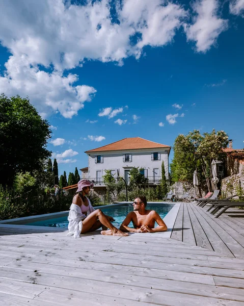 Casa vacanza francese con terrazza in legno e piscina nell'Ardeche Francia. Coppia rilassante a bordo piscina con terrazza in legno durante una vacanza di lusso in una casa vacanza nel sud della Francia — Foto Stock