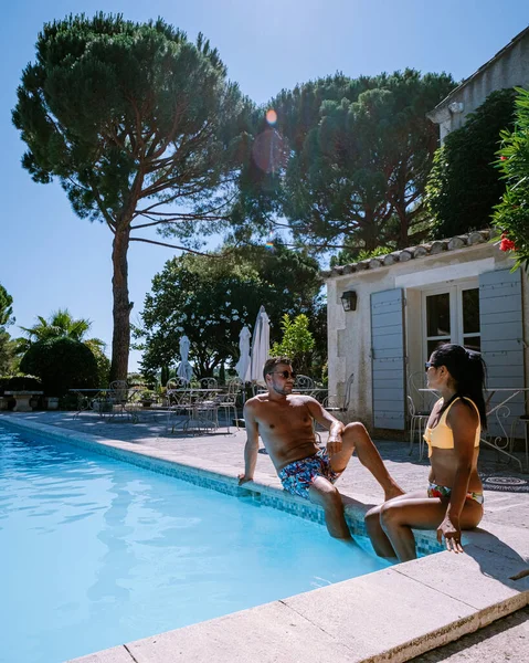 Пара відпочиває біля басейну у Провансі (Франція), а чоловіки і жінки відпочивають біля басейну на розкішному курорті. — стокове фото
