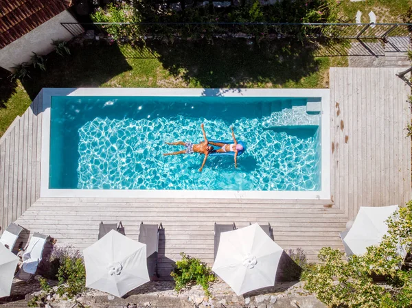 Duas pessoas nadam na piscina do hotel. Vista de cima, casal homens e mulheres na piscina de luxo casa de férias na Ardeche França — Fotografia de Stock