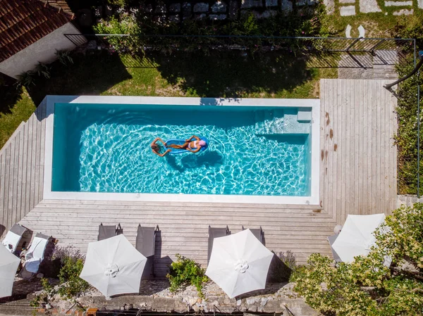 2 명이 수영장에서 수영하고 있어. 위에서 내려다볼 때, 프랑스 아르데 셰에 있는 호화 로운 휴가용 수영장에 앉아 있는 남녀들 — 스톡 사진