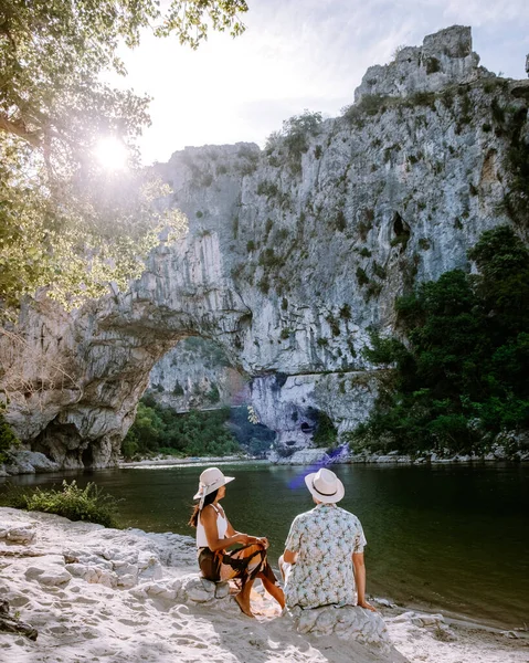 Пара на пляже у реки в Ardeche France Pont d Arc, Ardeche France, вид на Narural arch в Vallon Pont Darc в каньоне Ardeche во Франции — стоковое фото