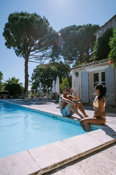Пара отдыха у бассейна в Провансе Франция, мужчины и женщины расслабляются у бассейна на роскошном курорте — стоковое фото