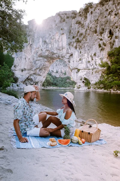 Пара на пляже у реки в Ardeche France Pont d Arc, Ardeche France, вид на Narural arch в Vallon Pont Darc в каньоне Ardeche во Франции — стоковое фото