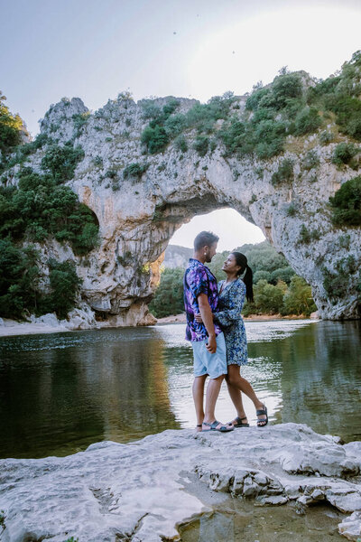 couple on the beach by the river in the Ardeche France Pont d Arc, Ardeche France,view of Narural arch in Vallon Pont Darc in Ardeche canyon in France