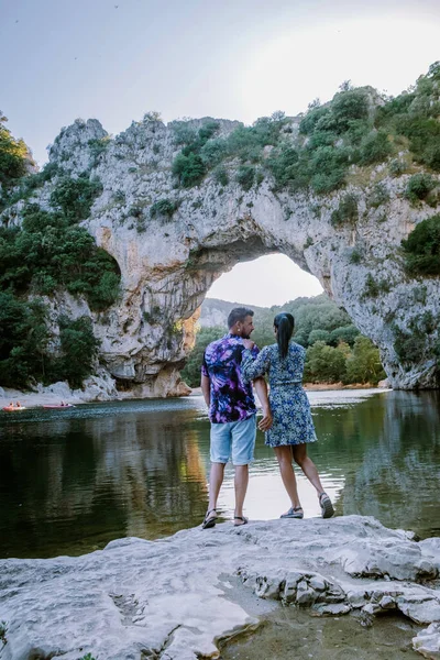 Пара на пляже у реки в Ardeche France Pont d Arc, Ardeche France, вид на Narural arch в Vallon Pont Darc в каньоне Ardeche во Франции — стоковое фото