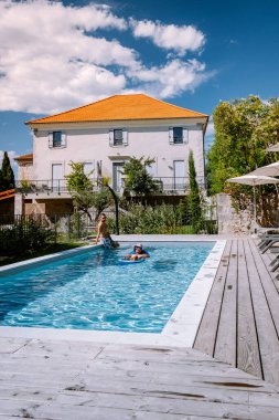 Ardeche Fransa 'da ahşap güverteli ve yüzme havuzlu bir Fransız tatil evi. Fransa 'nın güneyindeki bir tatil evinde, havuz kenarında ahşap güvertelerle dinlenen çift.