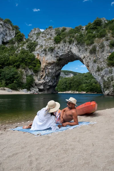 Paar aan het strand bij de rivier in de Ardeche France Pont d Arc, Ardeche Frankrijk, uitzicht op Narural arch in Vallon Pont Darc in Ardeche canyon in Frankrijk — Stockfoto