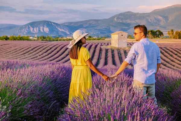 Couple men and woman on vacation at the provence lavender fields, Provence, Lavender field France, Valensole Plateau, colorful field of Lavender Valensole Plateau, Provence, Southern France. Lavender