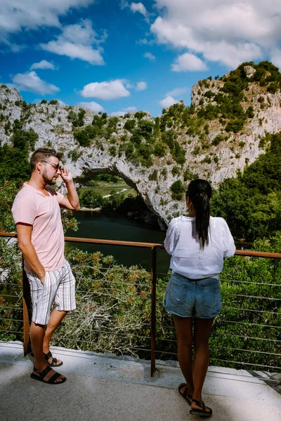 Pareja en la playa junto al río en el Ardeche Francia Pont d Arc, Ardeche Francia, vista del arco narural en Vallon Pont Darc en el cañón de Ardeche en Francia — Foto de Stock