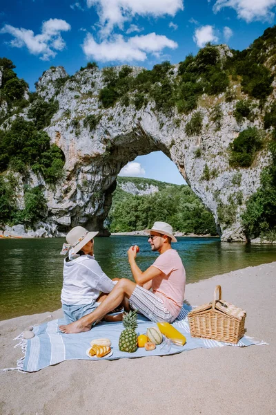 Couple sur la plage au bord de la rivière dans l'Ardèche France Pont d'Arc, Ardèche France, vue de l'arche Narural à Vallon Pont Darc dans le canyon de l'Ardèche en France — Photo