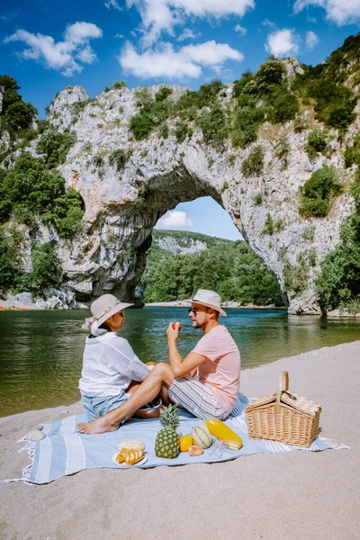 Casal na praia junto ao rio no Ardeche França Pont d Arc, Ardeche França, vista do arco Narural em Vallon Pont Darc no cânion Ardeche na França — Fotografia de Stock