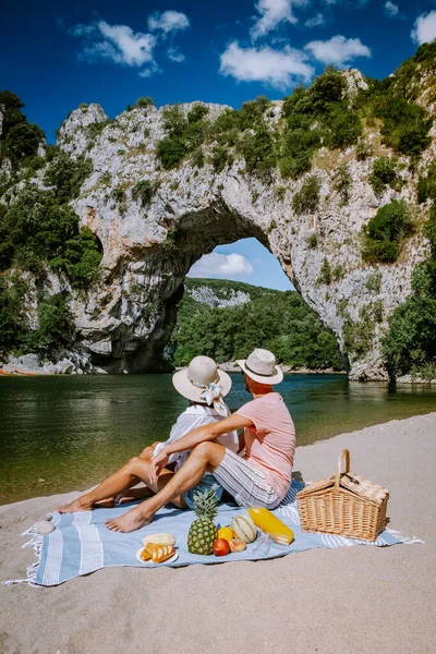 Пара на пляже у реки в Ardeche France Pont d Arc, Ardeche France, вид на Narural arch в Vallon Pont Darc в каньоне Ardeche во Франции — стоковое фото