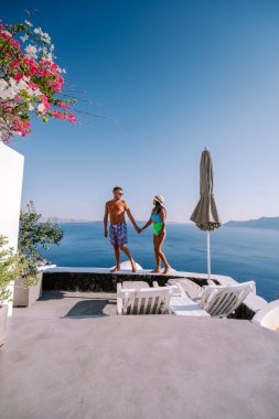 Santorini Yunanistan, genç çift güneş doğarken mavi kubbe kilisesi ve beyazlatılmış Oia Santorini köyünün gündoğumunu izlemek için Santorini Adası 'nda lüks bir tatile çıktılar.