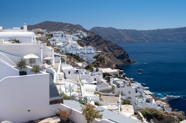 Yunanistan 'ın Santorini Adası' nda gün batımı, güzel, bembeyaz bir köy olan Oia 'da gün batımında kilise ve yel değirmeni.