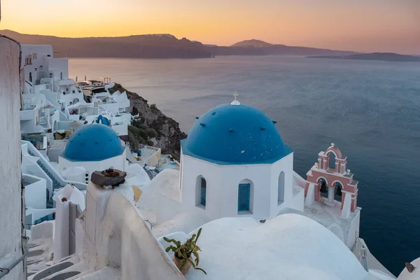 Puesta de sol en la isla de Santorini Grecia, hermoso pueblo encalado Oia con iglesia y molino de viento durante la puesta del sol —  Fotos de Stock