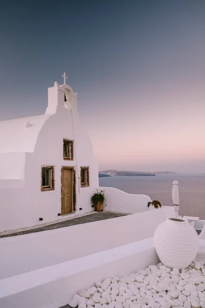 Naplemente a sziget Santorini Görögország, gyönyörű fehérre meszelt falu Oia templom és szélmalom naplementekor — Stock Fotó