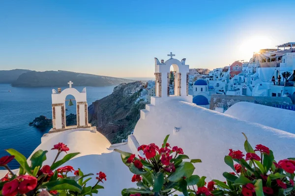 Puesta de sol en la isla de Santorini Grecia, hermoso pueblo encalado Oia con iglesia y molino de viento durante la puesta del sol — Foto de Stock