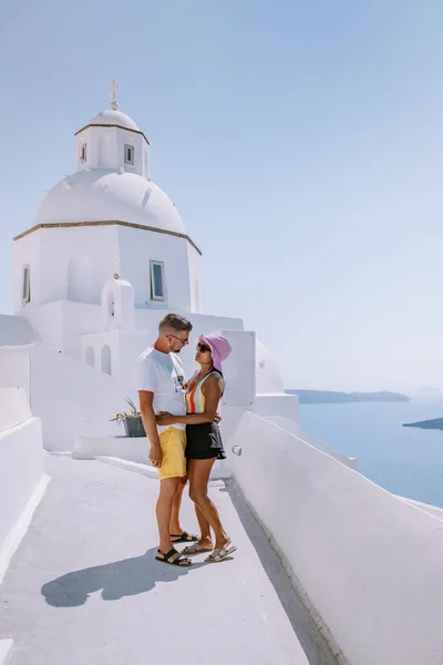Casal homens e mulheres de férias Santorini, Vista para o mar e Vulcão de Fira, a capital da ilha de Santorini, na Grécia — Fotografia de Stock