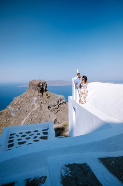 Santorini 'de tatilde olan çift erkek ve kadın, denize bakıyor ve Yunanistan' ın Santorini adasının başkenti Fira 'dan yanardağ.