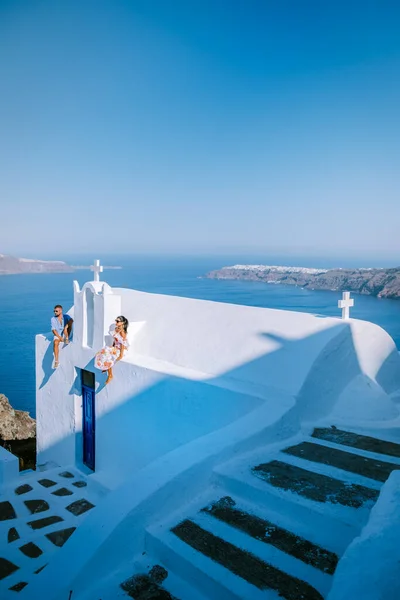 Paar Männer und Frauen im Urlaub Santorin, Blick auf das Meer und den Vulkan von Fira, der Hauptstadt der Insel Santorin in Griechenland — Stockfoto