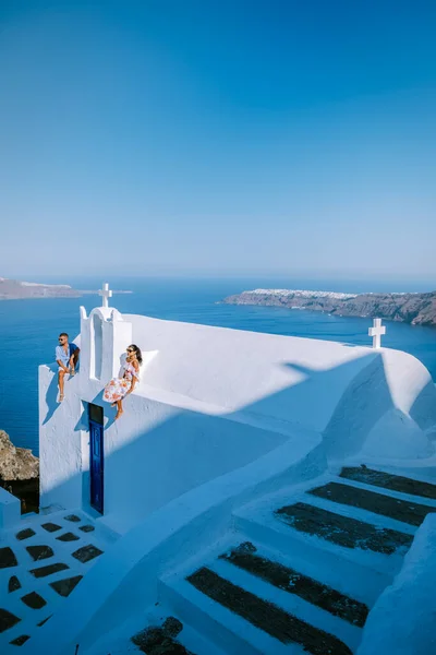 Pareja de hombres y mujeres de vacaciones Santorini, Vista al mar y al volcán desde Fira la capital de la isla de Santorini en Grecia — Foto de Stock
