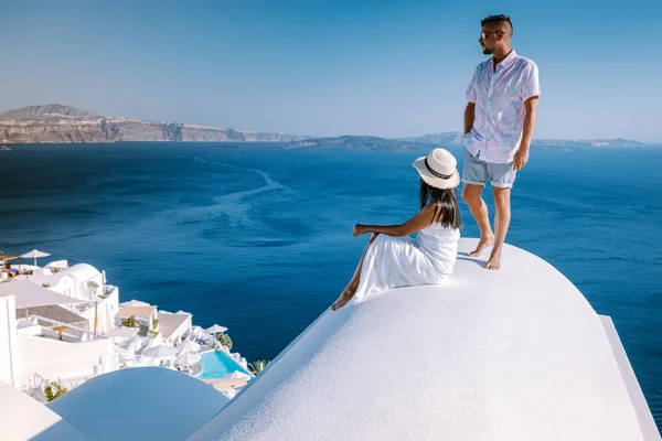Paar Männer und Frauen im Urlaub Santorin, Blick auf das Meer und den Vulkan von Fira, der Hauptstadt der Insel Santorin in Griechenland — Stockfoto
