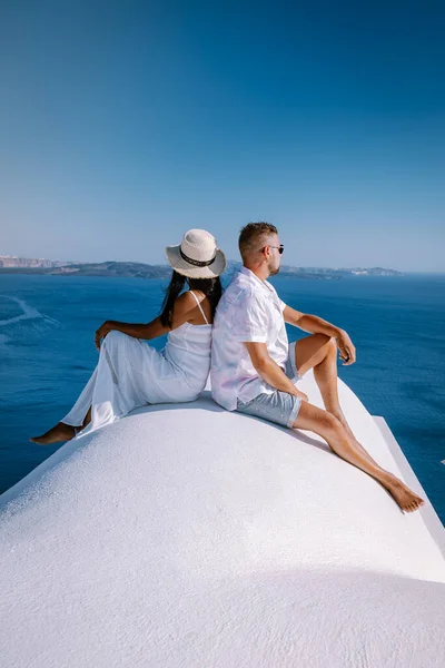 Pareja de hombres y mujeres de vacaciones Santorini, Vista al mar y al volcán desde Fira la capital de la isla de Santorini en Grecia — Foto de Stock