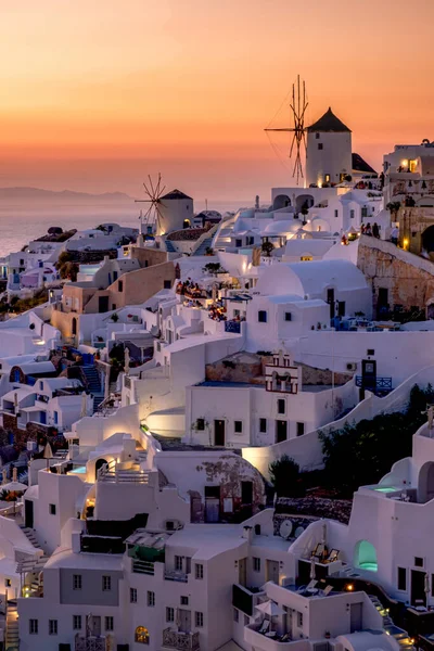 Sonnenuntergang auf der Insel Santorin Griechenland, schönes weiß getünchtes Dorf Oia mit Kirche und Windmühle bei Sonnenuntergang — Stockfoto