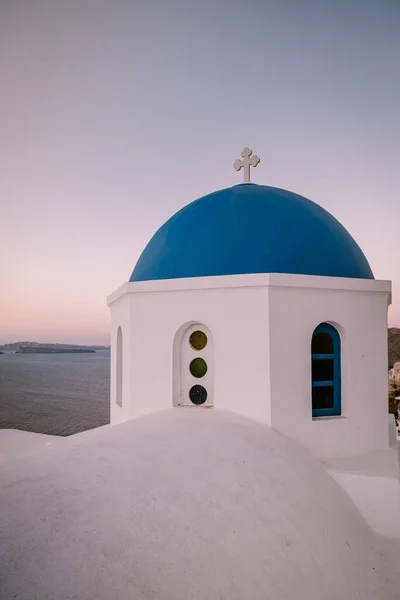 Pôr do sol na ilha de Santorini Grécia, bela aldeia caiada de branco Oia com igreja e moinho de vento durante o pôr do sol — Fotografia de Stock