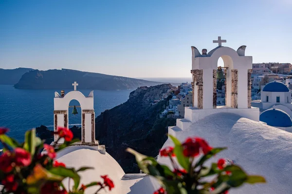 Solnedgång på ön Santorini Grekland, vackra vitkalkade byn Oia med kyrka och väderkvarn under solnedgången — Stockfoto