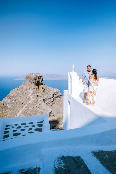 Pareja de hombres y mujeres de vacaciones Santorini, Vista al mar y al volcán desde Fira la capital de la isla de Santorini en Grecia — Foto de Stock